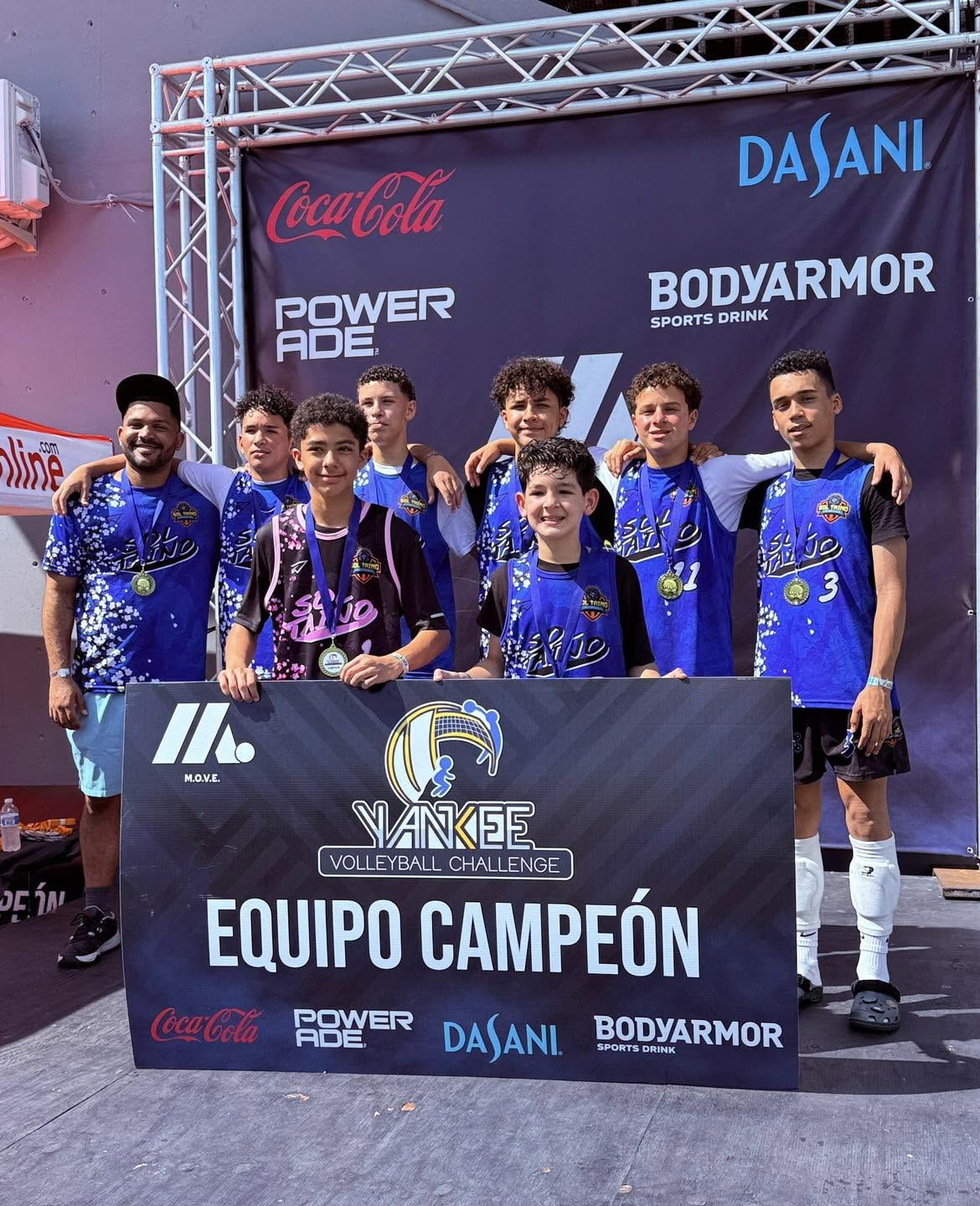 Equipo Sol Taíno con medallas y el cartel de Equipo Campeón del Yankee Volleyball Challenge